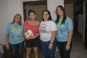 Rosiele Tenório recebeu das mãos das visitadoras 10 pacotes de leite em pó, que irão ajudar na alimentação dos filhos. Foto: Allan César / Secom Maceió
