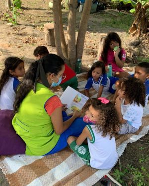 Crianças em momento de leitura sob a sombra da árvore. Foto: cortesia