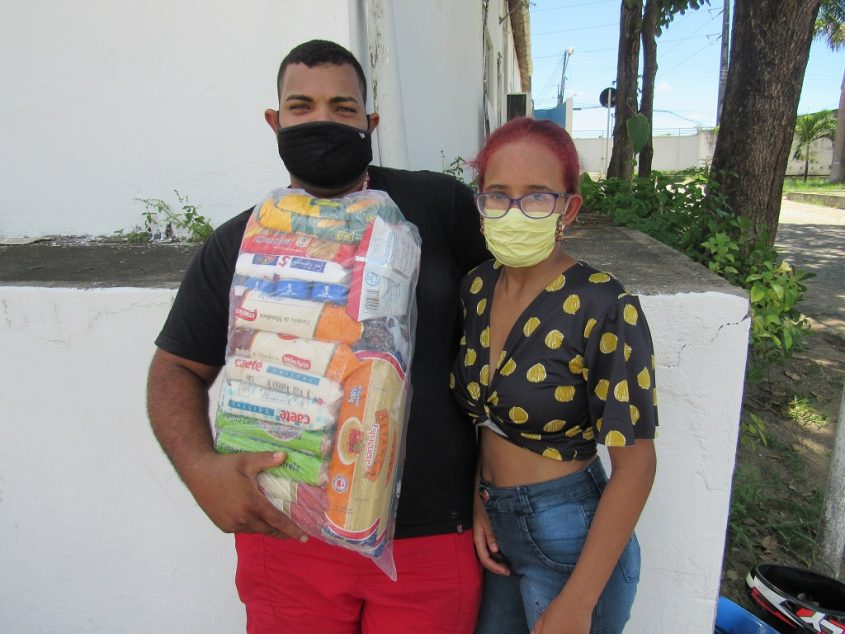 O casal, Wiliane Rodrigues e Luciano da Silva, recebem a cesta básica. Foto: Ascom Semas