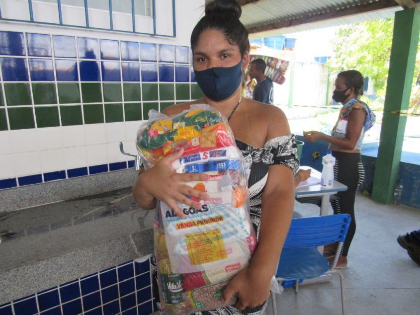 Dona de casa, Luanna July, recebe a cesta básica. Foto: Ascom Semas