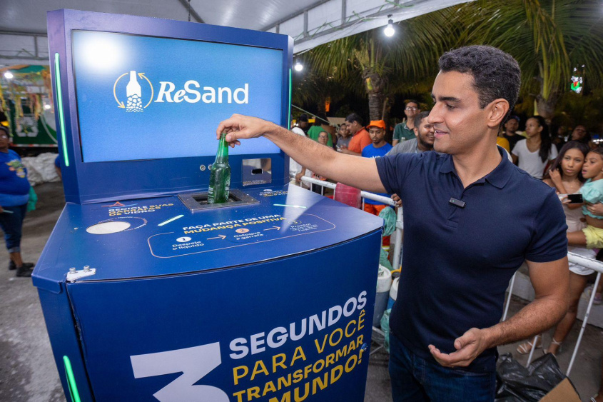 Novidade do evento, a máquina que transforma garrafas de vidro em areia foi testada pelo prefeito JHC. Foto: Secom Maceió