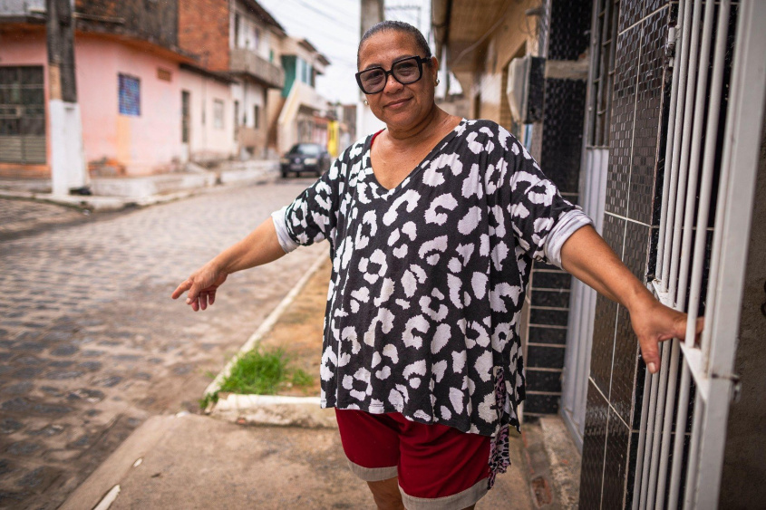 Maria Madalena esperou 23 anos para ver a rua onde mora, no Benedito Bentes, pavimentada e livre do lamaçal. Foto: Alisson Frazão